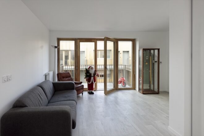 living area with couch and wood-framed glass doors open to a balcony
