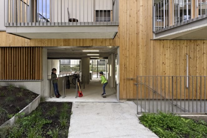 people walking in covered space under wood apartment building
