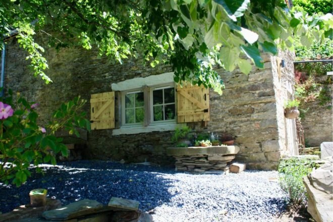stone home with wooden window shutters