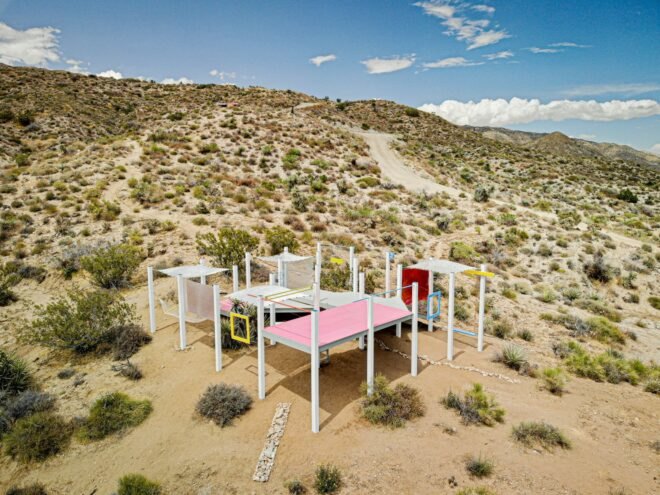 a pink and white platform elevated off the landscape
