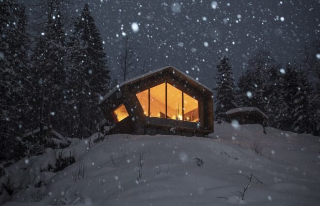 wood cabin on snowy hill at night