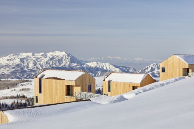 timber cabins atop of snowy mountain