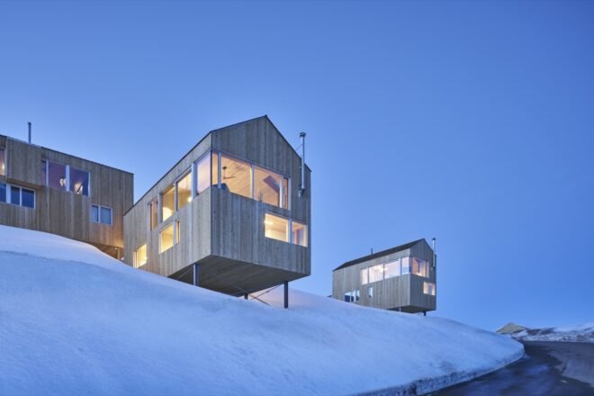 timber ski cabins surrounded by snow on a hill