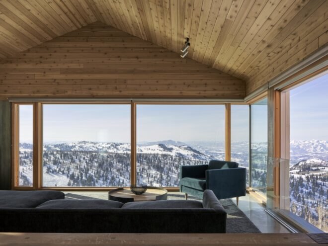 interior of wooden cabin with wood ceiling and large windows