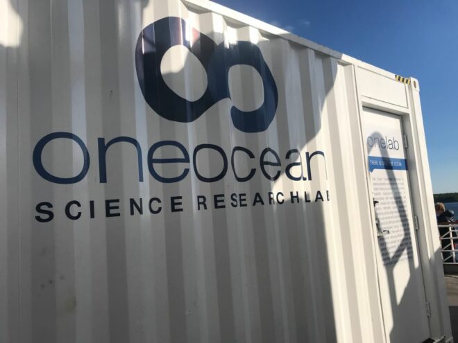 corrugated metal building with sign that reads "One Ocean Science Research Lab"