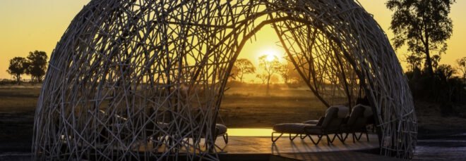 lounge chairs under woven dome at sunset