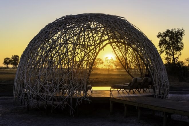 lounge chairs under woven dome at sunset