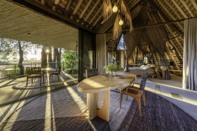 wood table with chairs and large canopy bed