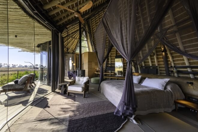 large canopy bed in room with glass walls