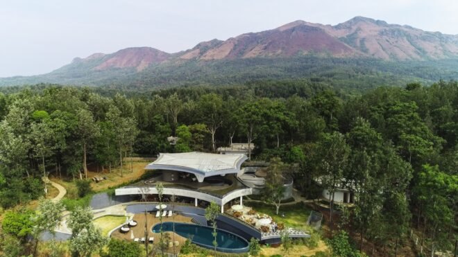 large white building with geometric roof and pool