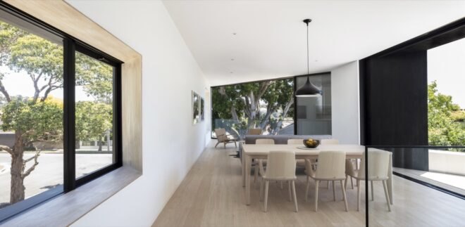 open-plan living area with light wood dining table and large windows