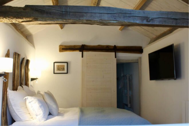 bedroom with wooden beams exposed in the ceiling