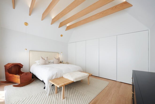 large white bedroom with light wood ceiling beams