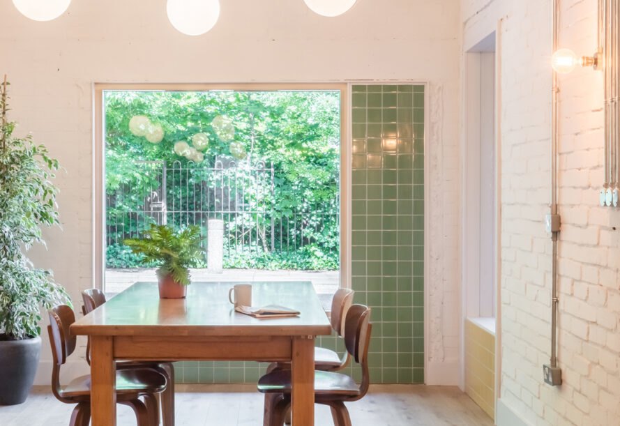 wood table beside large window revealing views of outdoor plants