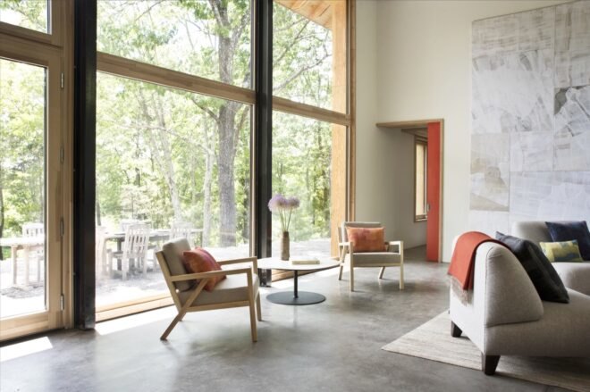 two tan chairs by massive glass windows