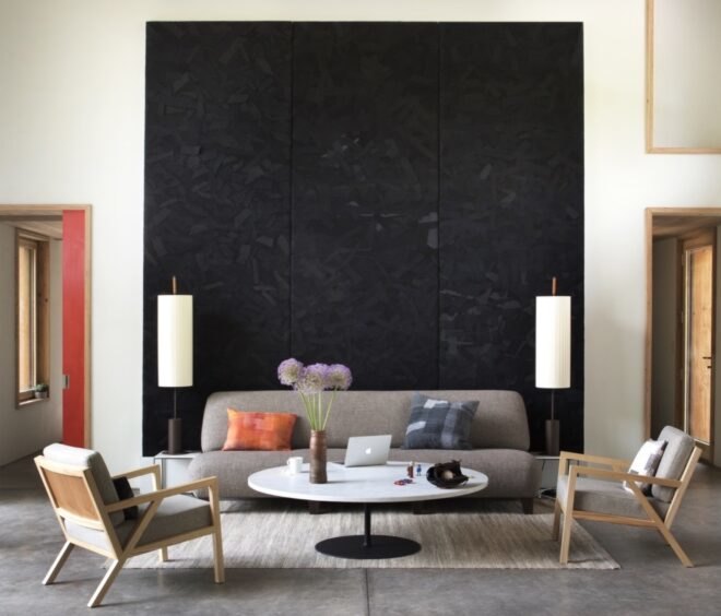 beige sofa and chairs in front of black wall art