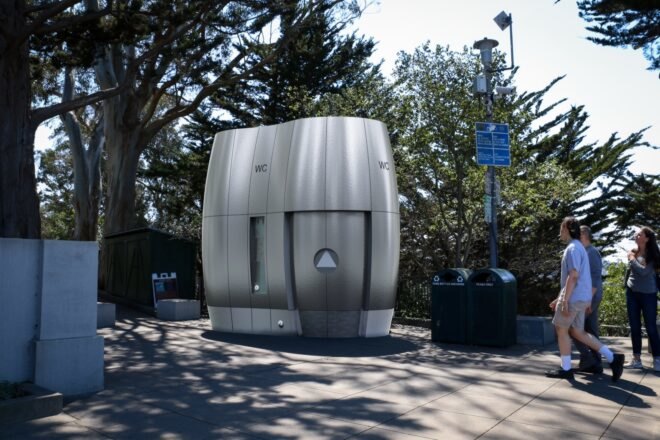 small curved metal bathroom unit in a city