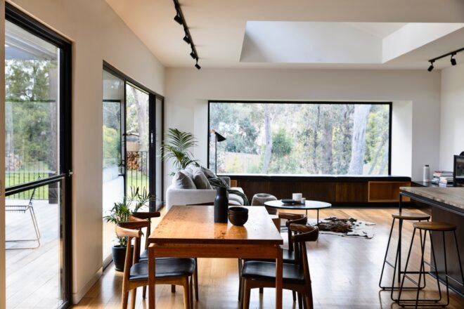 wood dining table and gray sofa in white living area
