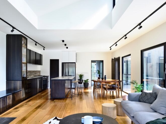white open-plan living area with wood floors, gray sofa and wood table