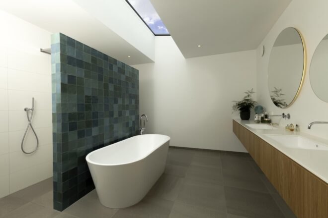 bathroom with freestanding tub and wall of blue tiles