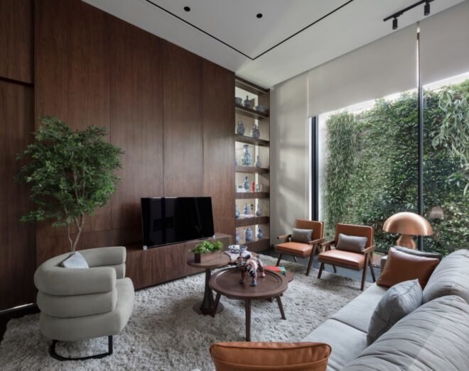 gray sofa facing dark wood wall with TV and bookcase