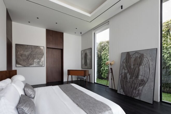 white bedroom with large pieces of artwork