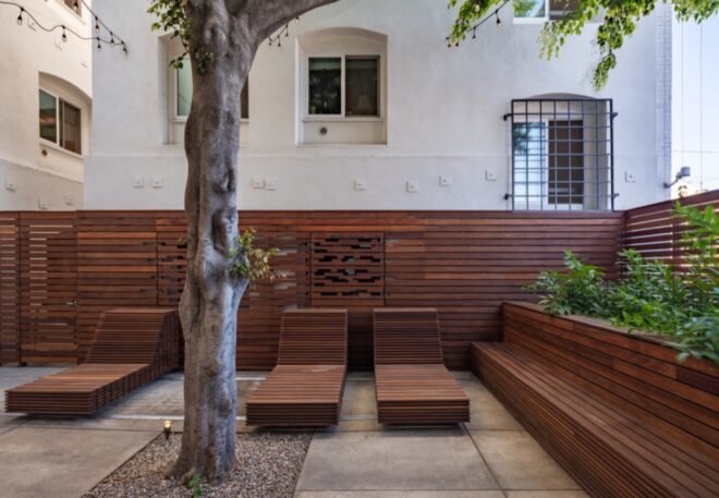 wood lounge chairs and tree in courtyard