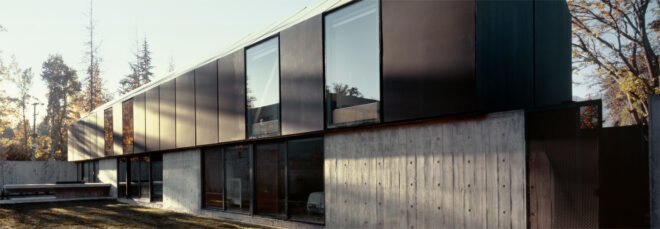 elongated black home with gabled roof