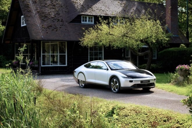 white electric car parked in front of black house