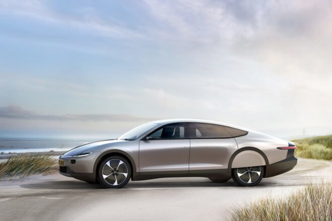 silver electric car driving past a beach