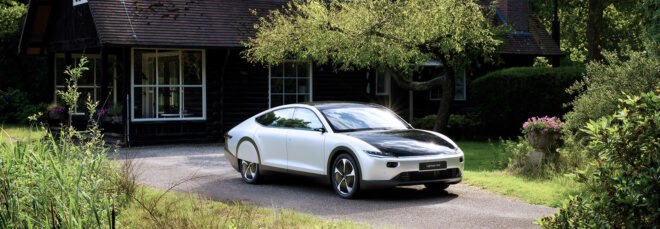 white electric car parked in front of black house