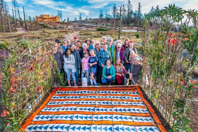 group of people smiling beside garden with patterned seed paper