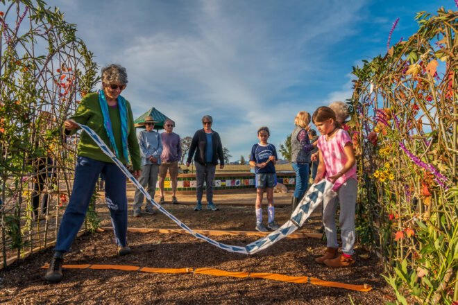 people arranging seed paper on a garden bed