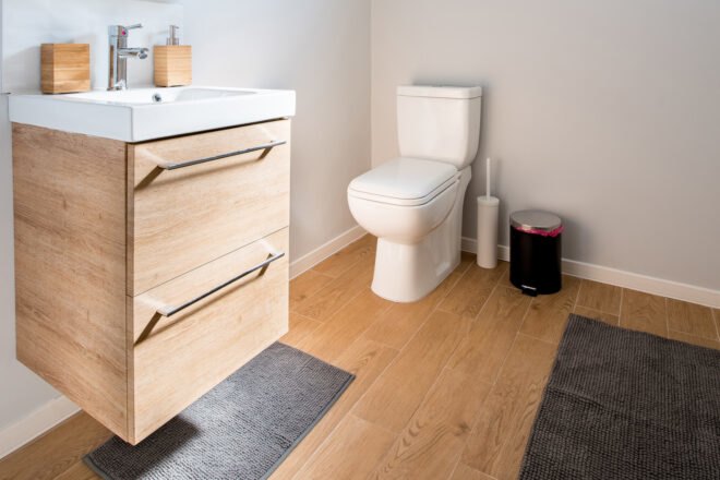 bathroom with toilet and wood cabinet