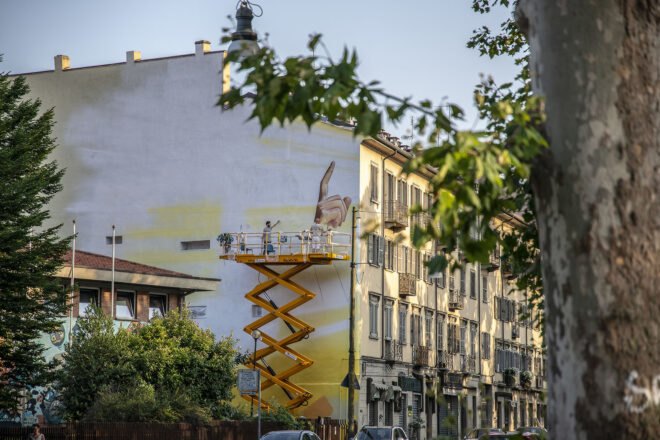 people on a lift painting a wall