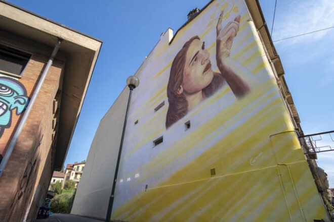 painting of a girl on a yellow building