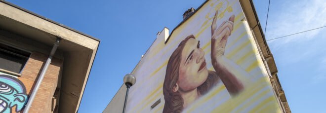 painting of a girl on a yellow building