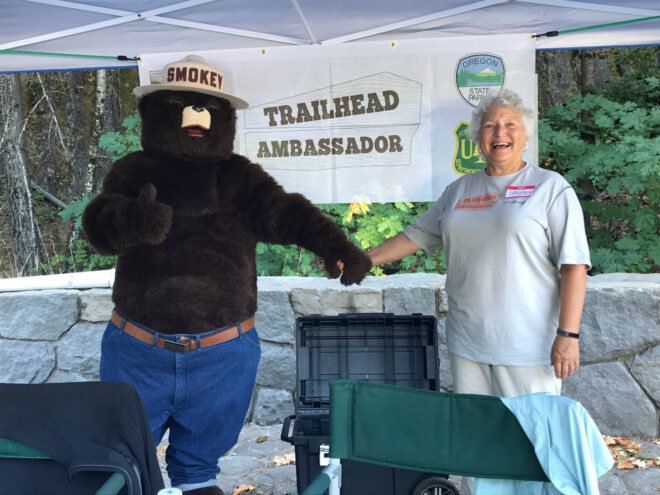 person holding hands with Smokey the Bear