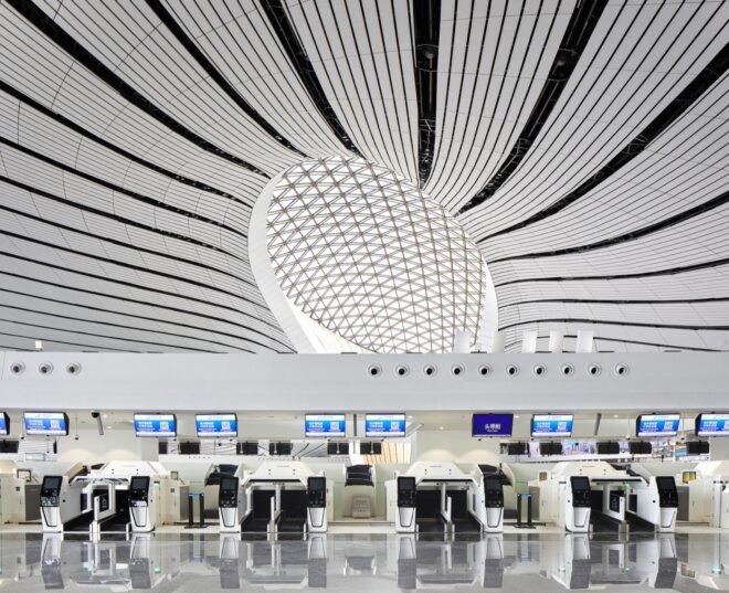 flight check-in computer screens inside a white airport