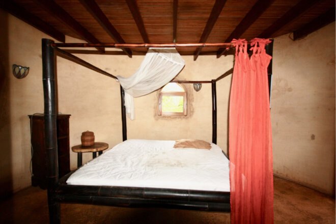 bed with iron canopy and red curtain