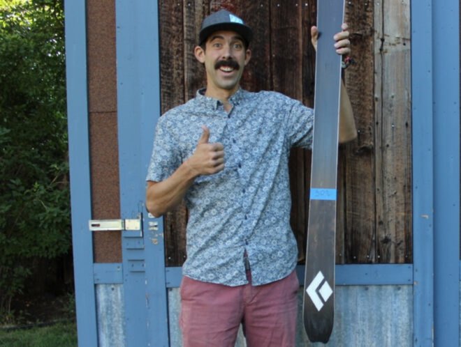 man holding up single ski