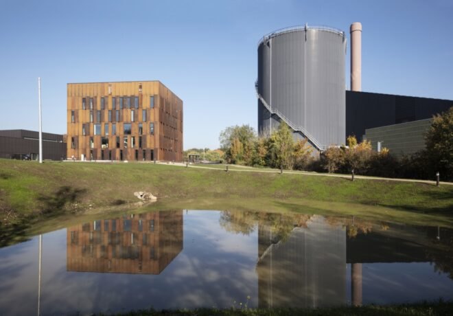 steel building surrounded by grass near a power plant