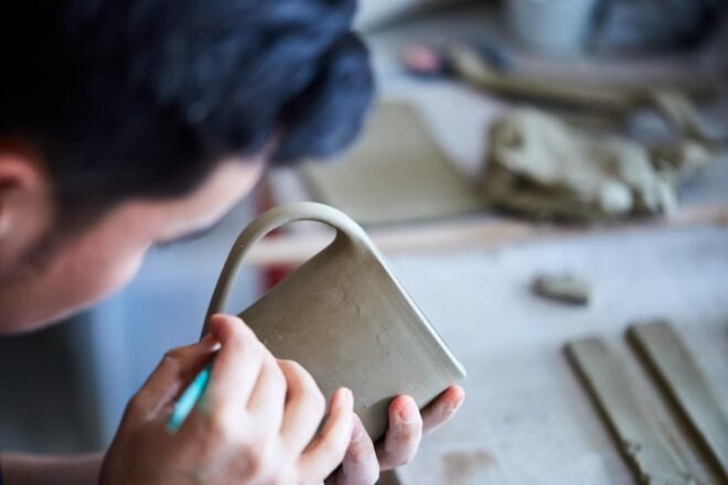 man inspecting ceramic mug