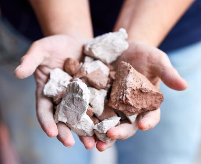 pair of hands holding rock pieces