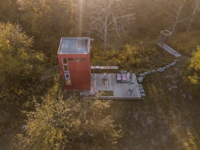 red tower with wooden deck in green field