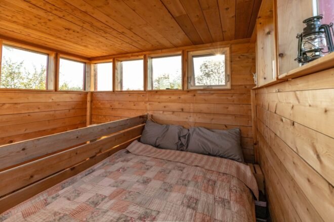 lofted bed inside wood-lined room