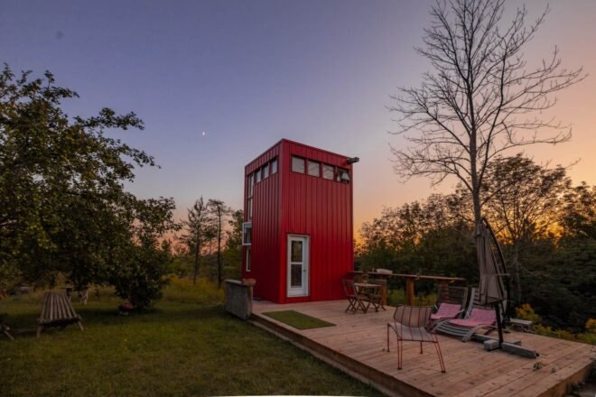 red tower with wooden deck in green field at dusk