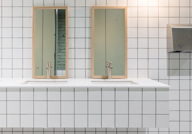 white-tiled bathroom with dual sinks