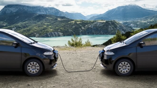 rendering of two electric cars charging each other near a lake