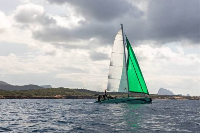 zero-emissions catamaran with green sail on the water